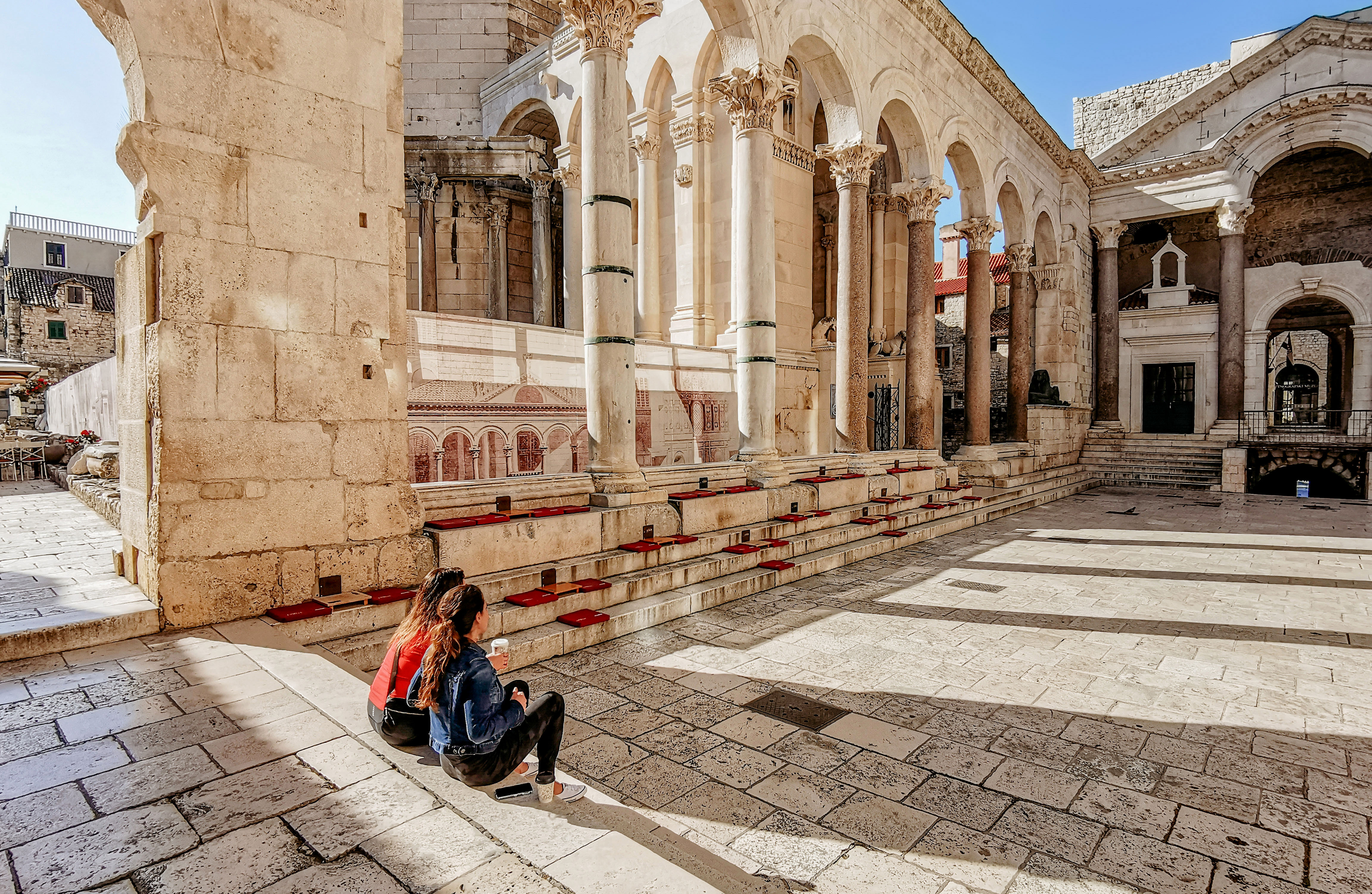 Two women exploring Diocletian's Palace in Split during summer vacation, Croatia