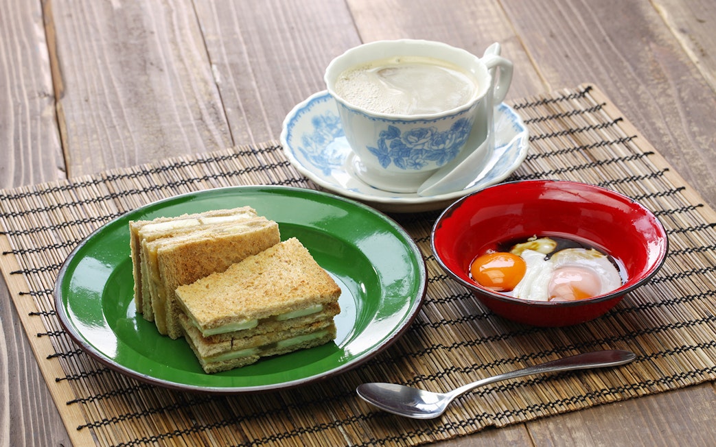 Kaya jam toast sandwich with white coffee and soft-boiled eggs, Singaporean Malaysian breakfast.