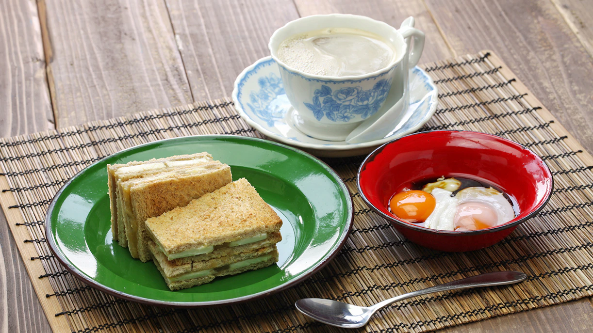 Kaya jam toast sandwich with white coffee and soft-boiled eggs, Singaporean Malaysian breakfast.