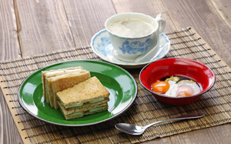 Kaya jam toast sandwich with white coffee and soft-boiled eggs, Singaporean Malaysian breakfast.