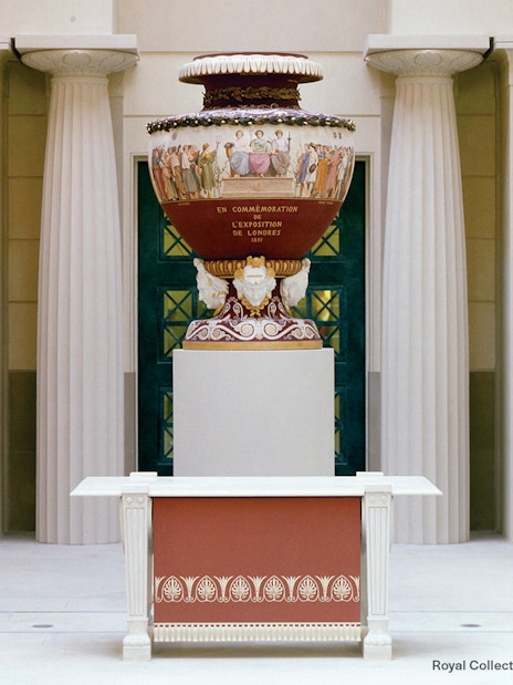 Decorative urn in Buckingham Palace with classical columns in the background.