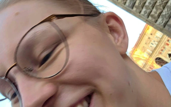I don't know who this is, but the image is a close-up of a person with glasses smiling, with a historic building in Bologna in the background.