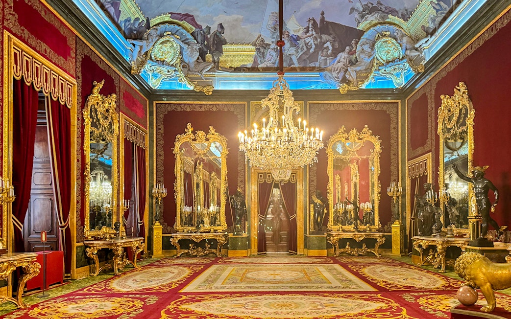 Throne room with ornate chandeliers and gilded mirrors in Royal Palace of Madrid.