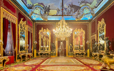 Throne room with ornate chandeliers and gilded mirrors in Royal Palace of Madrid.