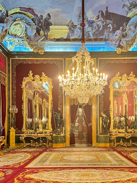 Throne room with ornate chandeliers and gilded mirrors in Royal Palace of Madrid.