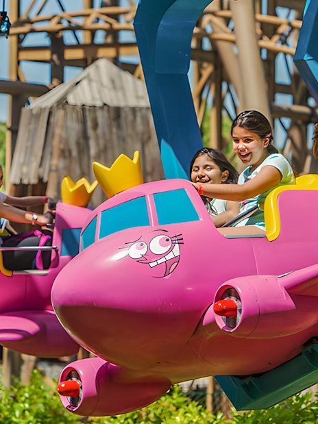Children enjoying the Flying Godfathers ride at Parque de Atracciones de Madrid.