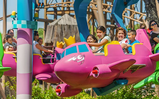 Children enjoying the Flying Godfathers ride at Parque de Atracciones de Madrid.