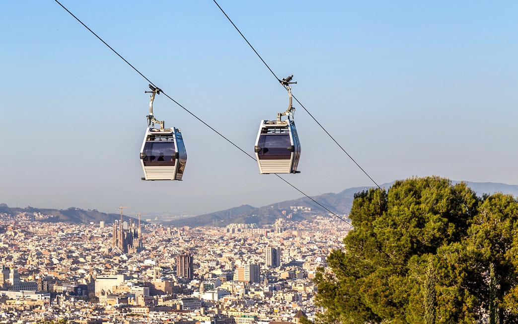 Cable car ascending Montjuic Hill with Sagrada Familia in background, Barcelona.