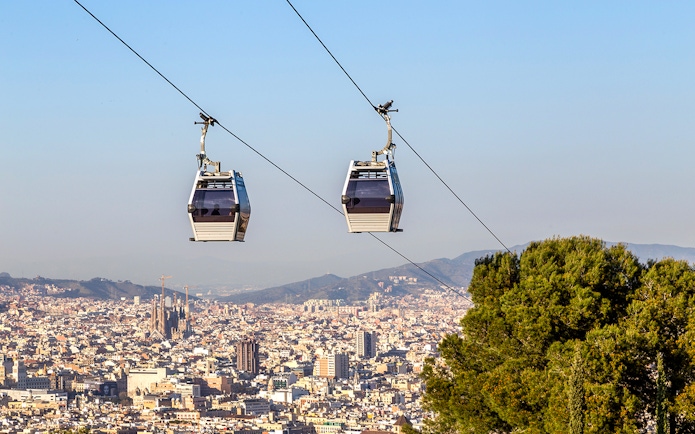 Cable car ascending Montjuic Hill with Sagrada Familia in background, Barcelona.