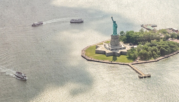 Statue of Liberty with ferries approaching, viewed from above, New York City.