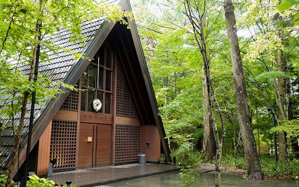 Karuizawa Glacier Shrine surrounded by lush green trees.