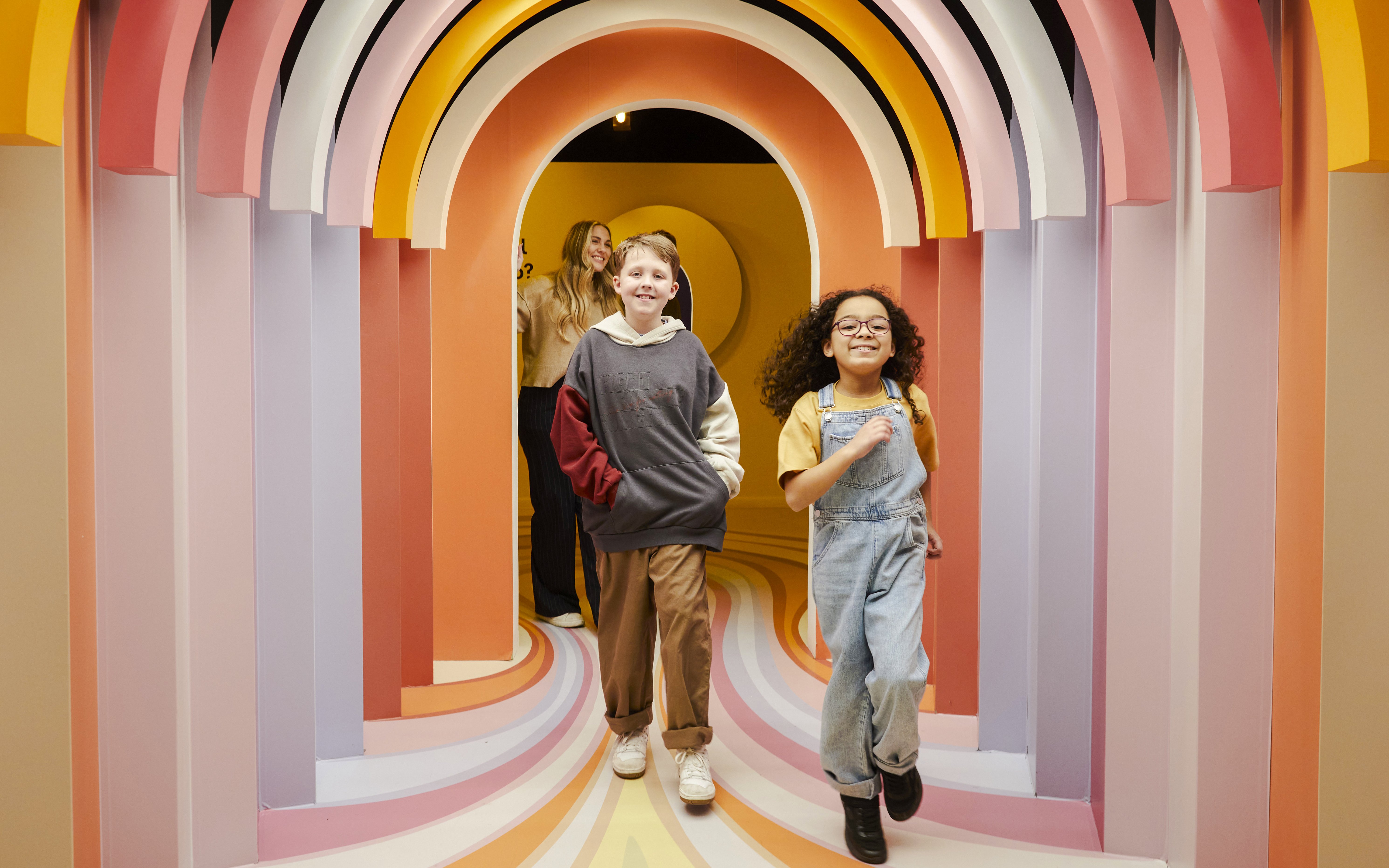Guests exploring colorful arches at the Twist Museum in London.