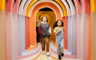 Guests exploring colorful arches at the Twist Museum in London.