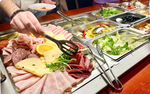 Buffet selection on Prague New Year's Eve cruise with meats, cheeses, and salads.