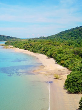 Cape Tribulation beach with lush greenery and clear blue waters in Queensland, Australia.