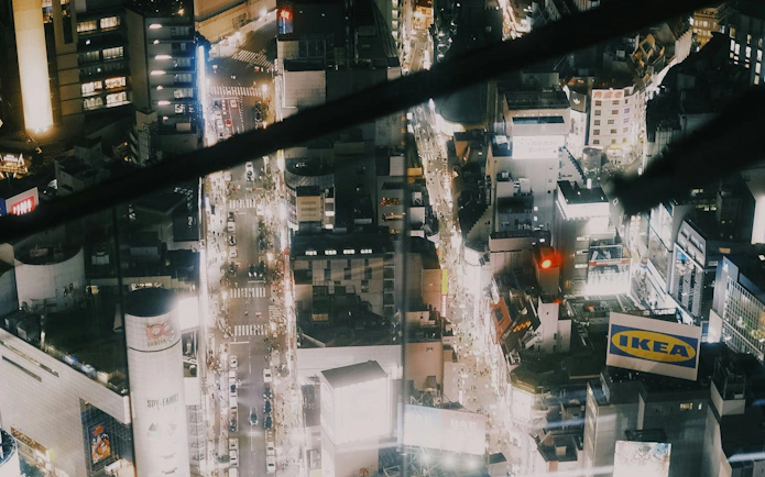 Aerial view of Shibuya at night with illuminated streets and buildings, Tokyo.