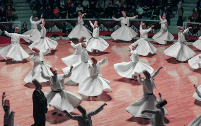 Whirling dervishes performing in Cappadocia, Turkey, showcasing traditional Sufi dance.