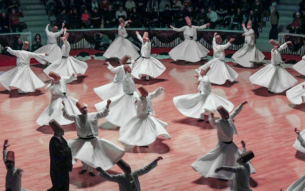 Whirling dervishes performing in Cappadocia, Turkey, showcasing traditional Sufi dance.