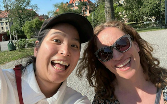 Two people smiling in a park on Södermalm, Stockholm, during a self-guided city exploration game.