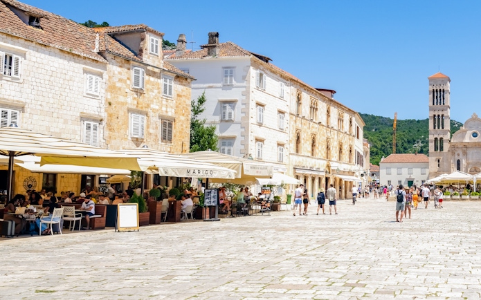 Historic square with cafes and stone buildings on Hvar Island, Croatia.