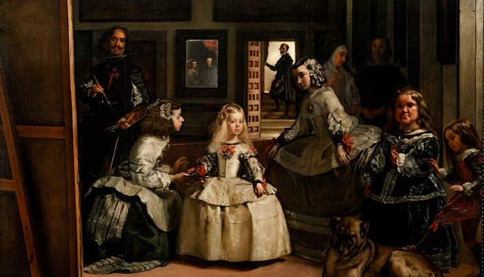 Visitors observing the famous Las Meninas painting at the Prado Museum in Madrid, Spain