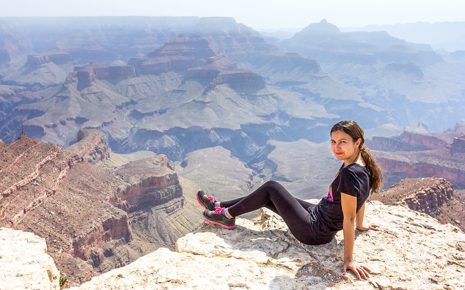 Woman standing at Shoshone Point, Grand Canyon, overlooking vast canyon landscape.