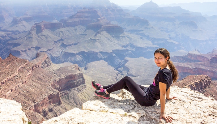 Woman standing at Shoshone Point, Grand Canyon, overlooking vast canyon landscape.