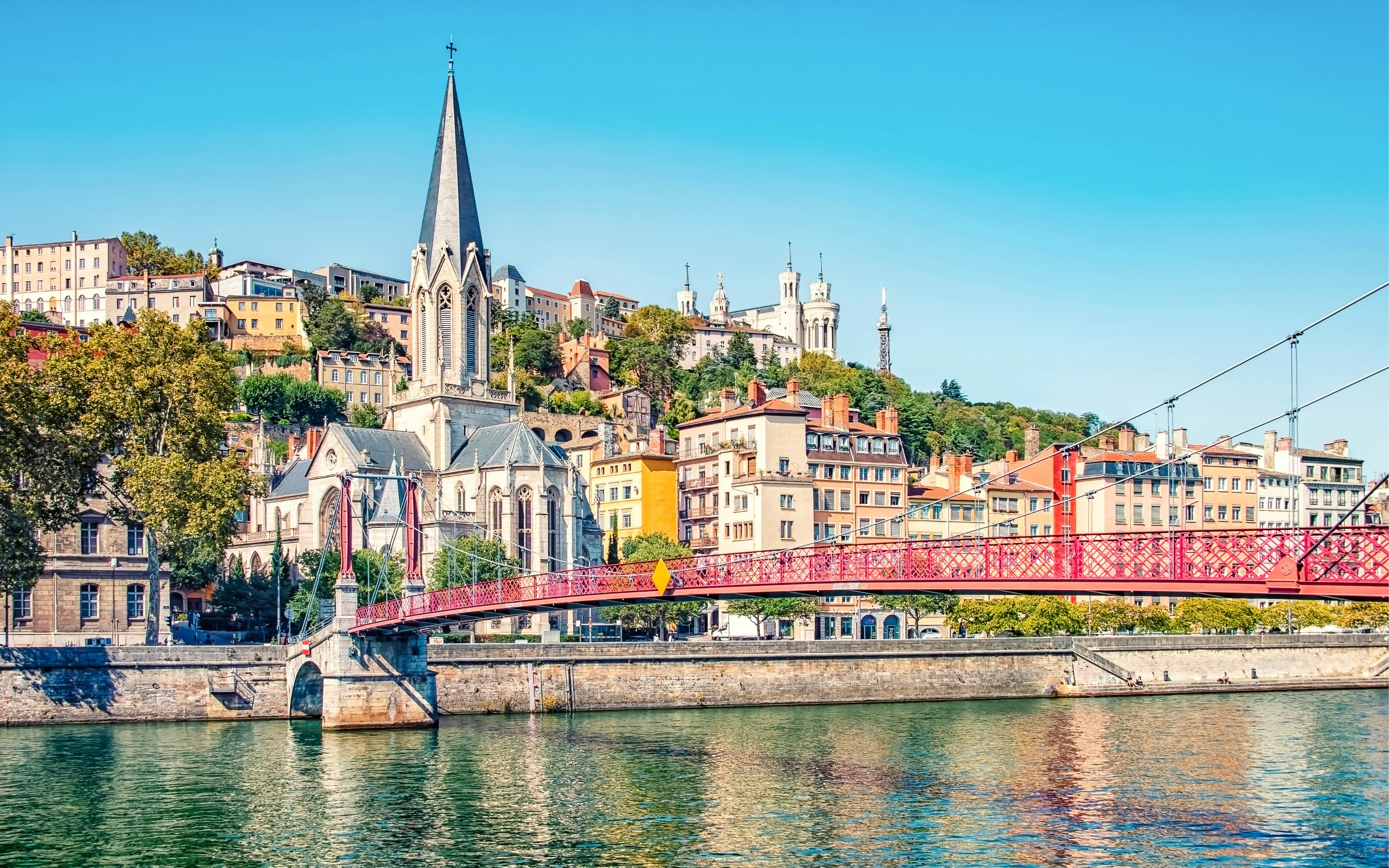 Pedestrian bridge over the Saône River with Fourvière Basilica in Lyon, France.