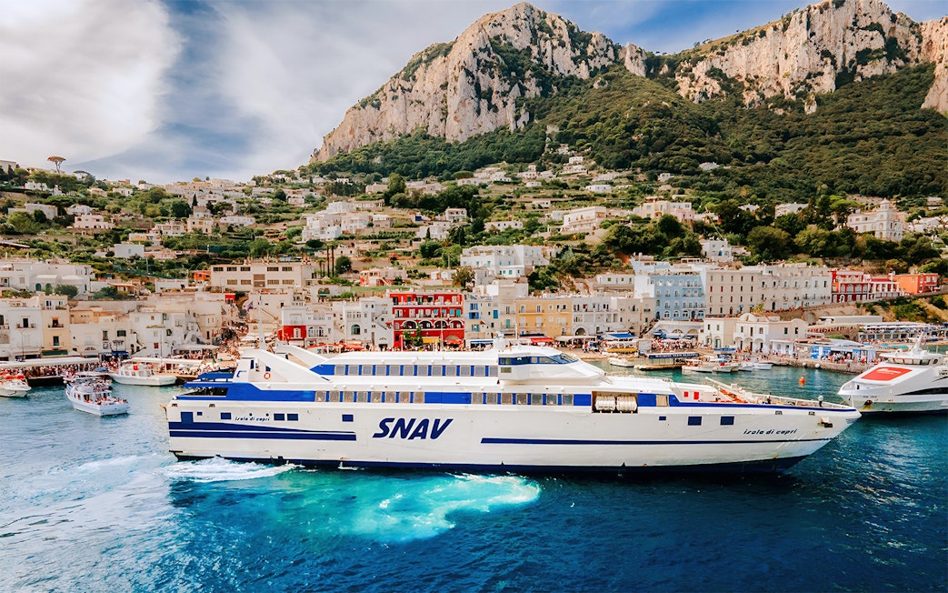 SNAV ferry sailing from Naples Beverello to Capri with island landscape in background.