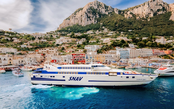 SNAV ferry sailing from Naples Beverello to Capri with island landscape in background.