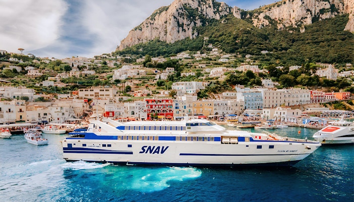 SNAV ferry sailing from Naples Beverello to Capri with passengers on deck enjoying the sea view.