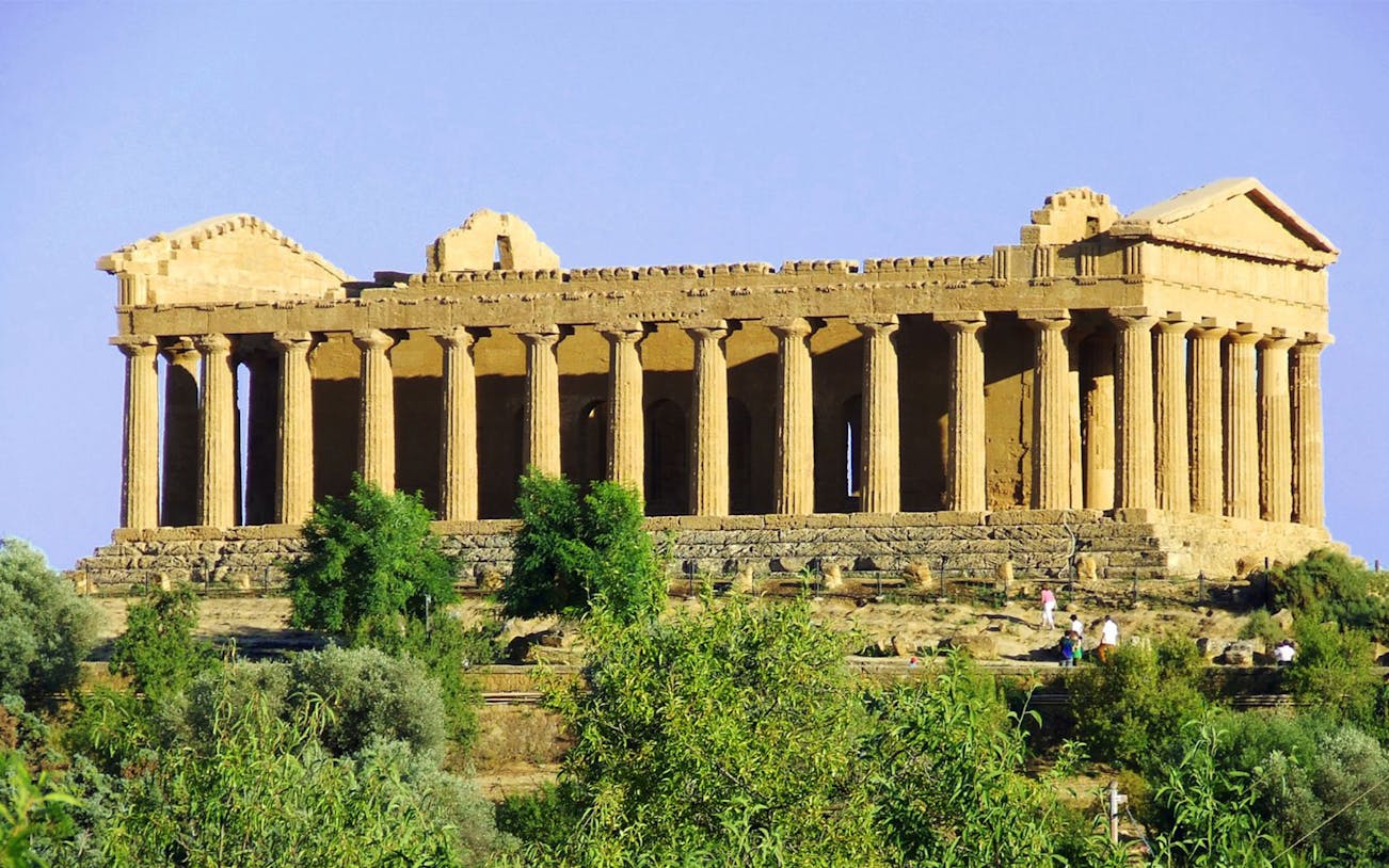 Ancient Greek temple in Agrigento, Sicily, surrounded by greenery.