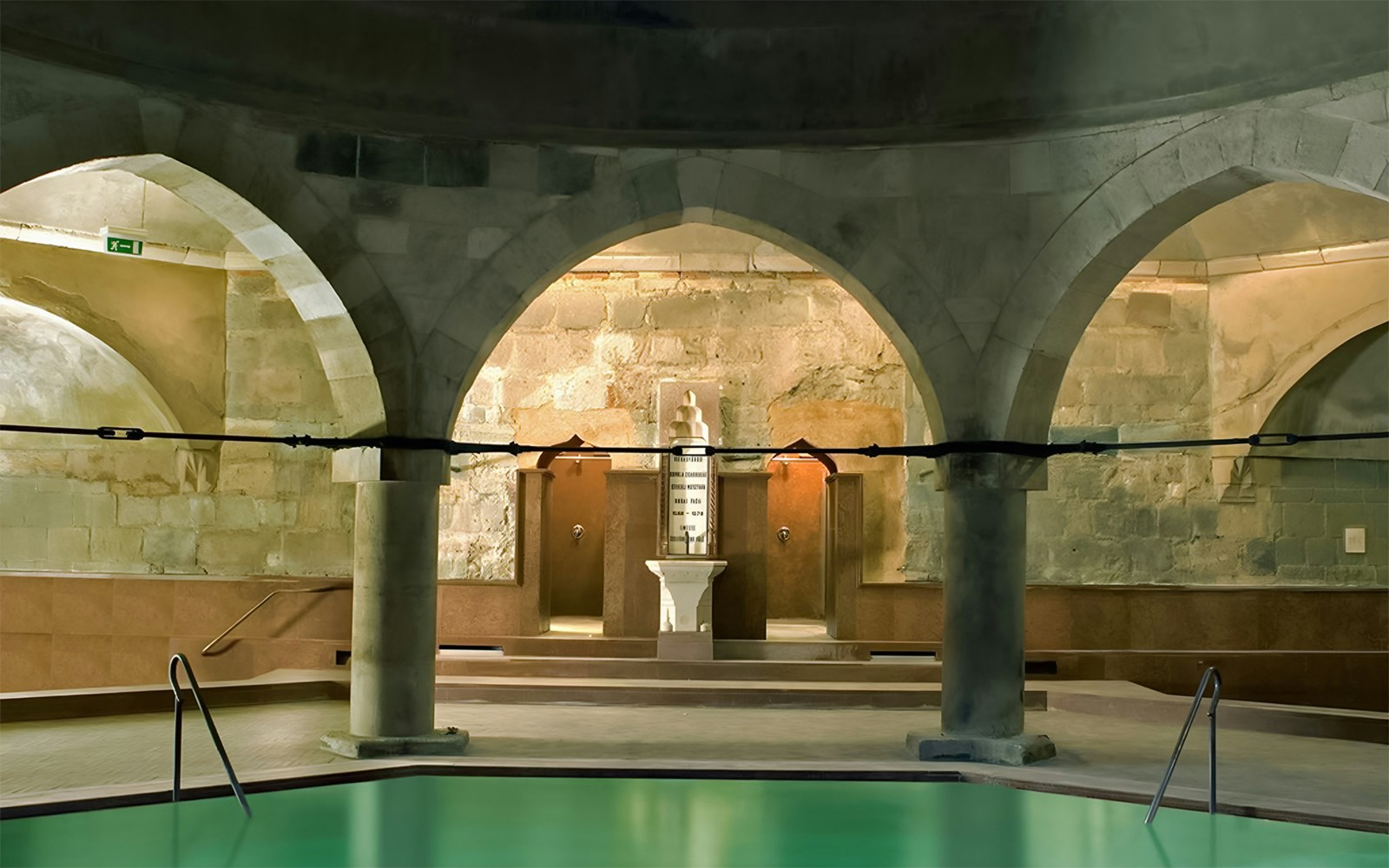 Rudas Thermal Spa interior at night with illuminated thermal pools and arched ceilings in Budapest, Hungary.