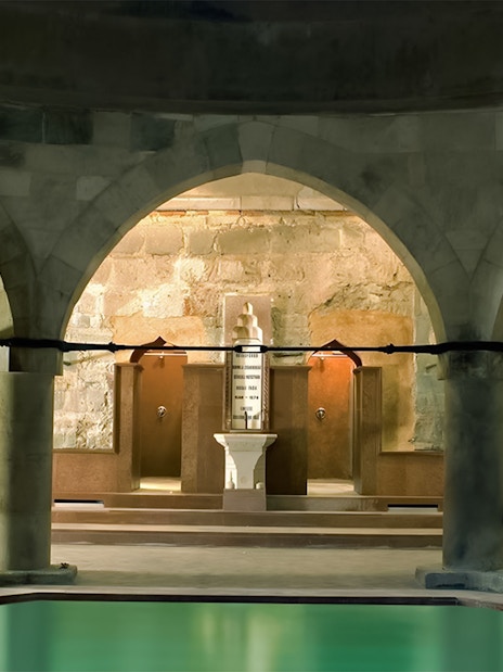 Rudas Thermal Spa interior with arches and pool at night.