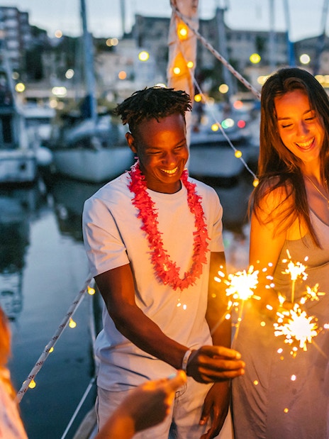 Group enjoying sparklers on Athens Riviera night party boat.