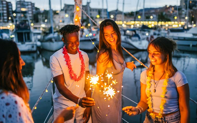 Group enjoying sparklers on Athens Riviera night party boat.