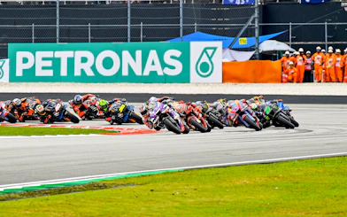 Motorcycle racers taking a sharp turn at Petronas Grand Prix of Malaysia 2023.