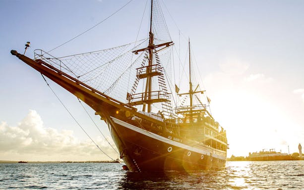 Pirate ship sailing at sunset on a dinner cruise.