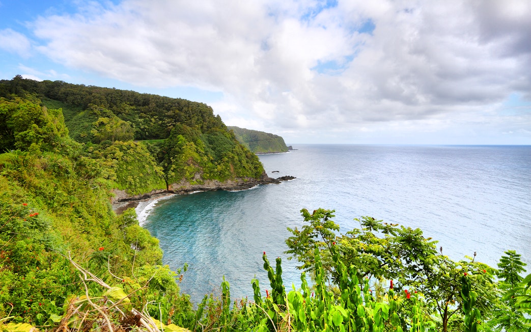 Coastal view along the Road to Hana, Maui, Hawaii with lush greenery and ocean.