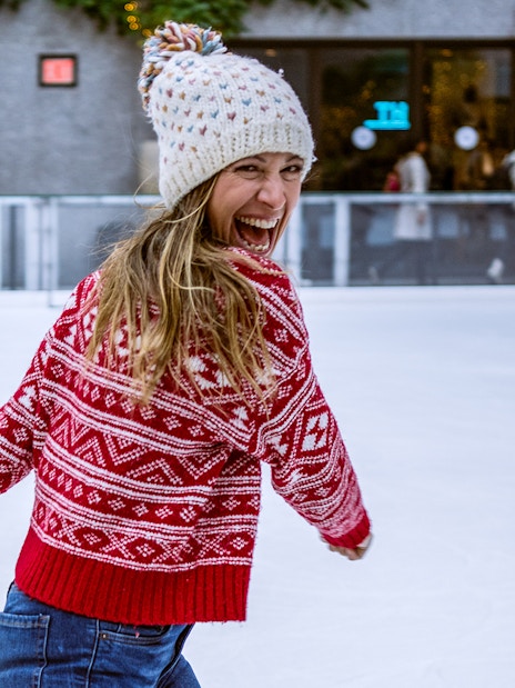 Person ice skating at Rockefeller Center's The Rink in New York City.