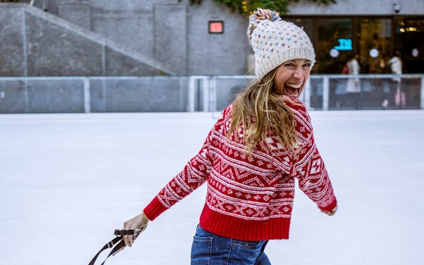 Person ice skating at Rockefeller Center's The Rink in New York City.