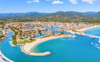 Aerial view of Port Grimaud with canals, boats, and sandy beaches on the St Tropez day tour from Nice.