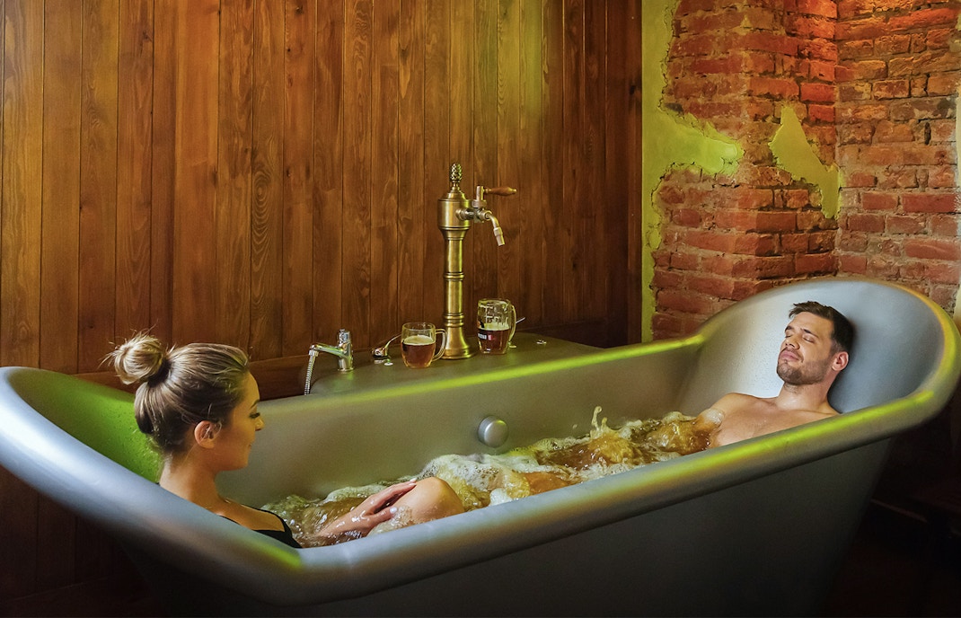 Prague beer and wine spa bath with salt cave experience featuring wooden tubs and stone walls.