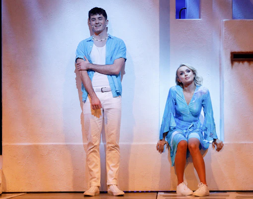 Actors performing a scene from Mamma Mia! musical on stage.