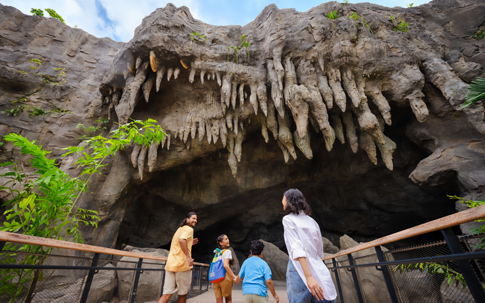 Family exploring cave entrance with stalactites at The Cavern.