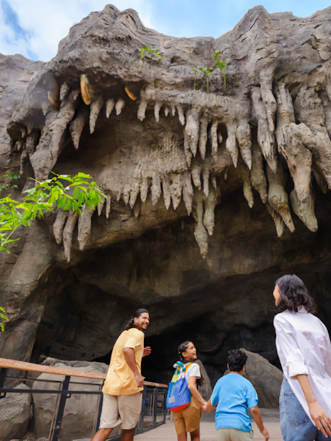 Family exploring cave entrance with stalactites at The Cavern.