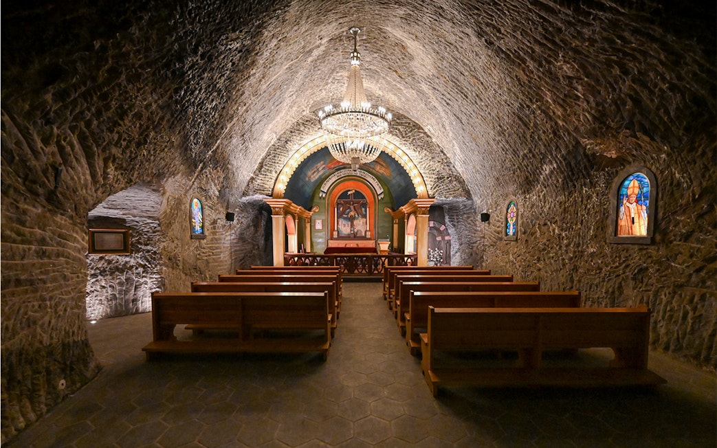 Underground church interior at Wieliczka Salt Mine with altar and chandeliers.