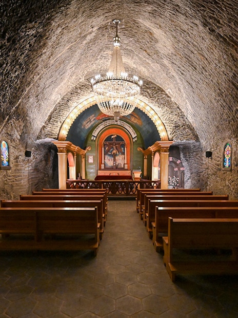 Underground church interior at Wieliczka Salt Mine with altar and chandeliers.