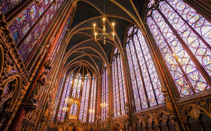 Sainte-Chapelle interior with ornate stained glass windows and vaulted ceiling in Paris.