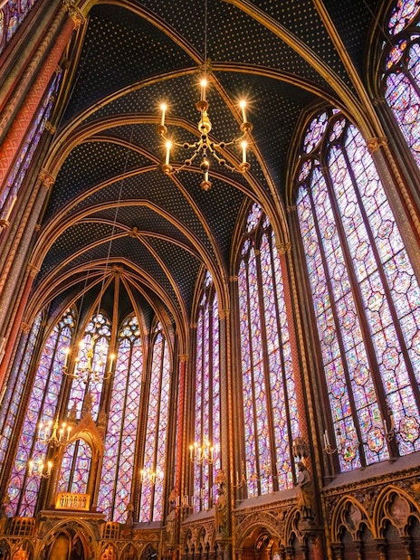 Sainte-Chapelle interior with ornate stained glass windows and vaulted ceiling in Paris.